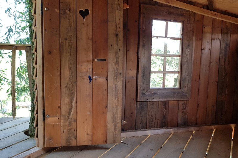 Binnenkant van een boomhut op maat, geheel voorzien van deur en raam met kozijnen.