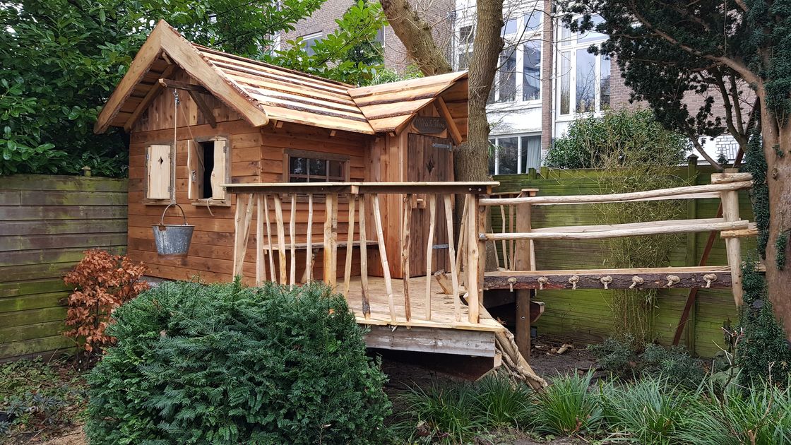 Een op maat gebouwde boomhut in een achtertuin.