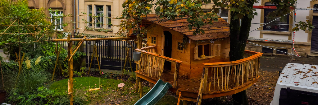 kinderboomhut met glijbaan en schommel in de tuin